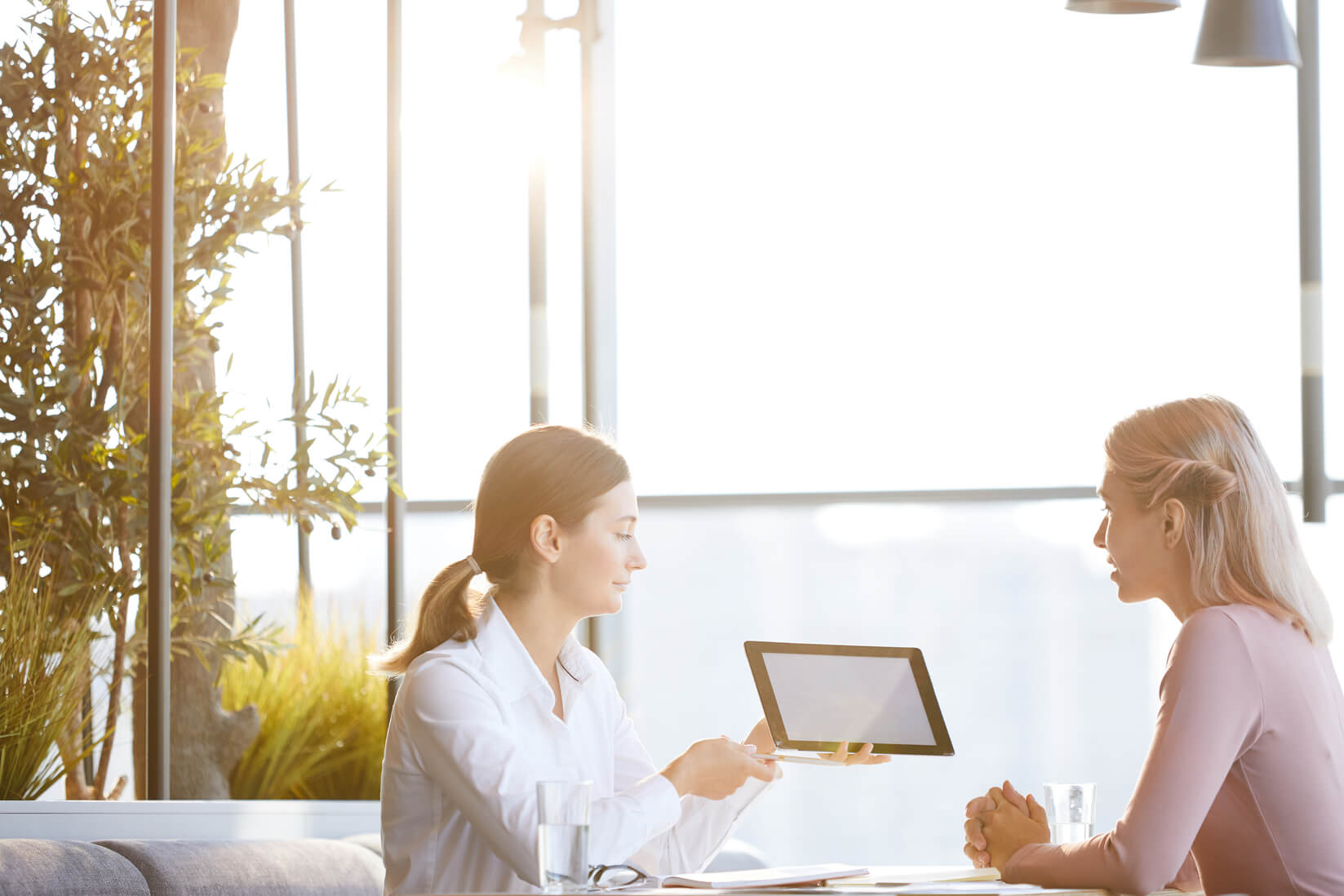 Two women discussing the power of outsourced marketing for their business.