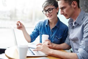 Two individuals discussing the marketing actions they need to take to achieve online success. 