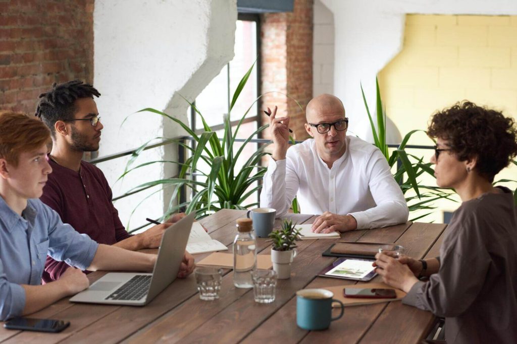 A business meeting where new marketers are comparing demand generation vs lead generation.