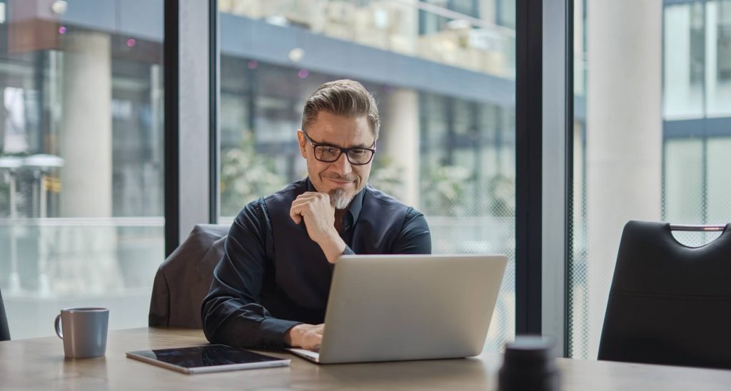 A small business marketing expert intensely focuses on their computer screen, analyzing data and strategizing.