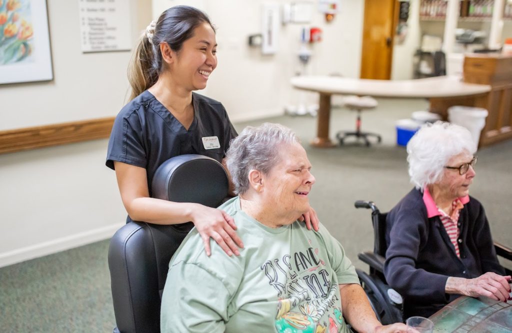 A care worker with two residents in a long-term care community