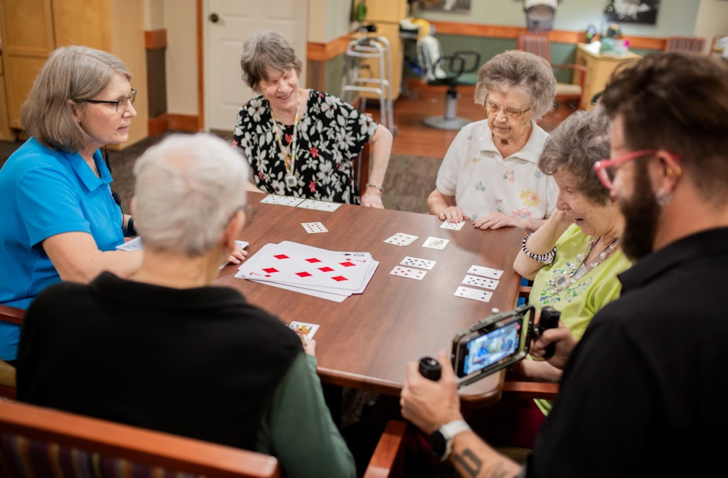 A documentary filmmaker filming residents playing cards