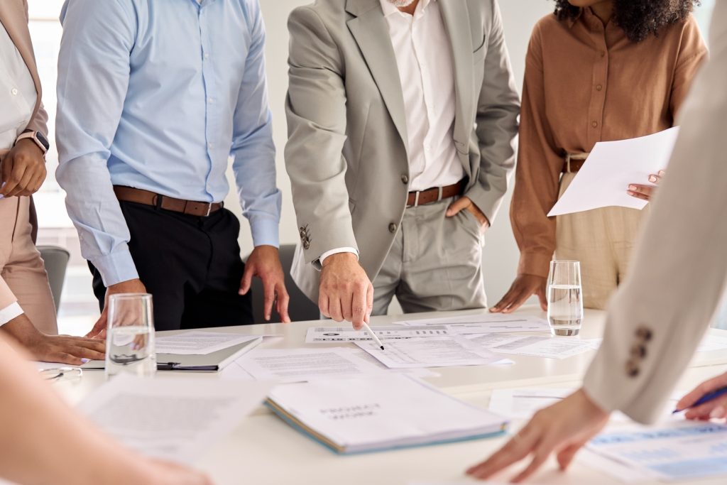 Group of professionals discussing financial advertising strategies around a table.