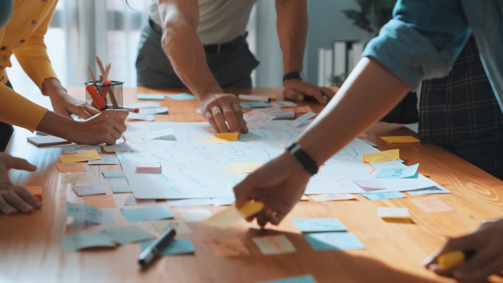Strategic marketing leadership team brainstorming with sticky notes and a creative strategy map.