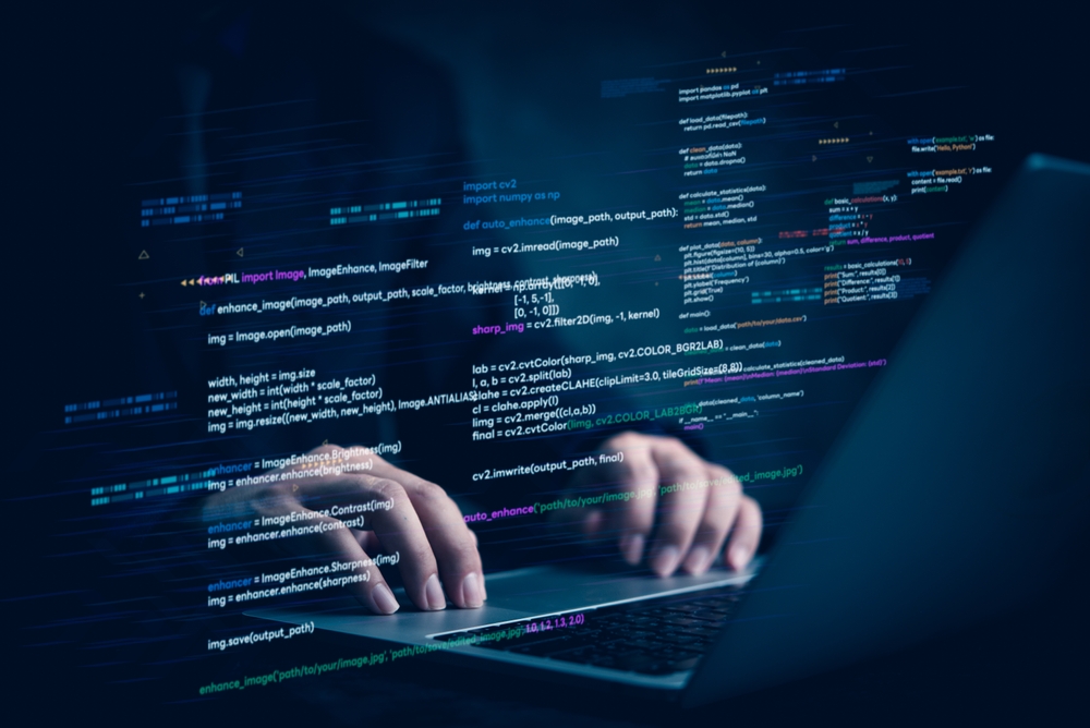 Hands typing on a laptop with colorful programming code projected on the screen, symbolizing the tech-focused communication behind how to market to developers through code-driven content and strategy.