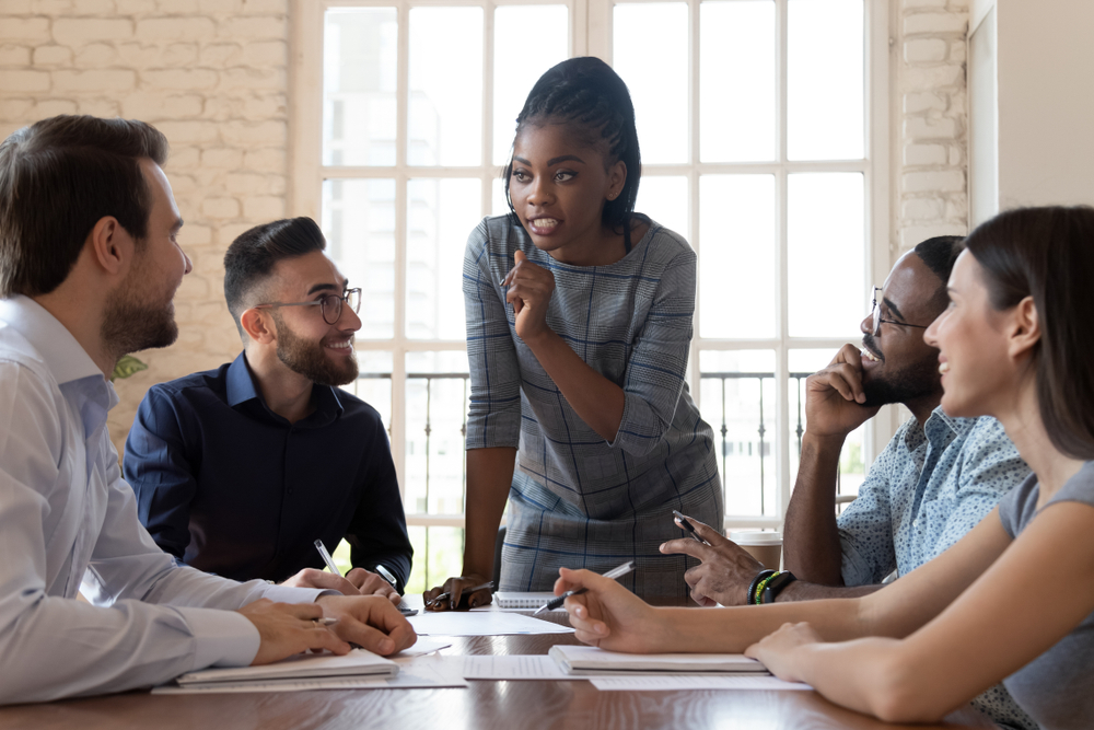 Fractional CMO leading a strategy discussion with a diverse marketing team around a conference table.