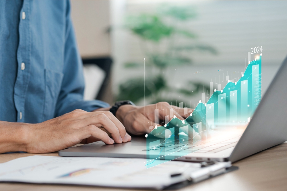 Close-up of a professional analyzing rising digital charts on a laptop, illustrating how a marketing team tracks performance data and drives growth metrics.