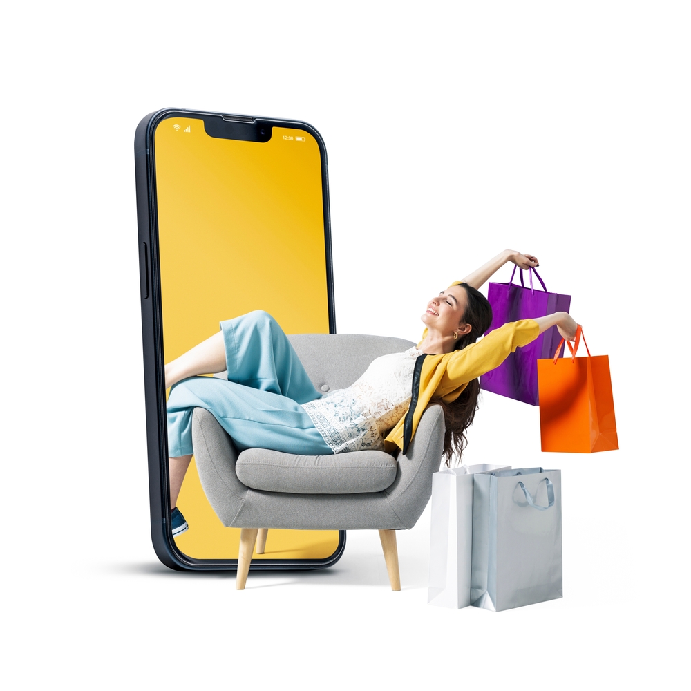 Mobile phone emerging behind a shopper with retail bags, illustrating modern ways to promote business online through digital experiences.