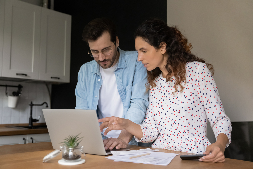 A couple searching for a plumbing service on their laptop, reflecting how marketing for plumbers is built around real homeowner behavior.