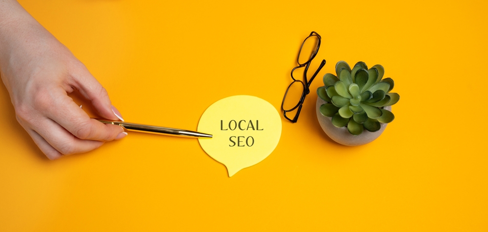 Local SEO concept with search tools and notes on a yellow background, representing a SaaS SEO agency strategy.