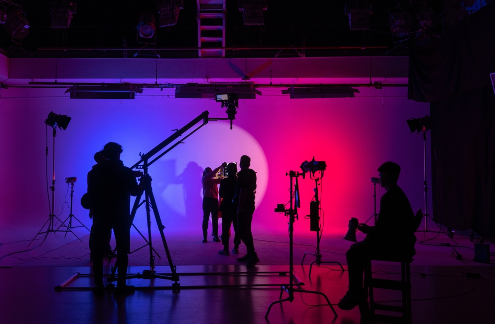Film crew working on a colorful studio set, illustrating storytelling in business through professional video production.