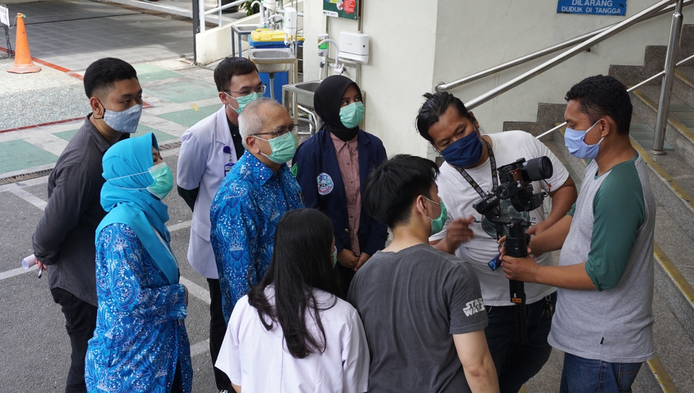 Healthcare professionals and a video production team collaborating on location, illustrating a healthcare marketing plan built around real people, authentic stories, and visual communication.