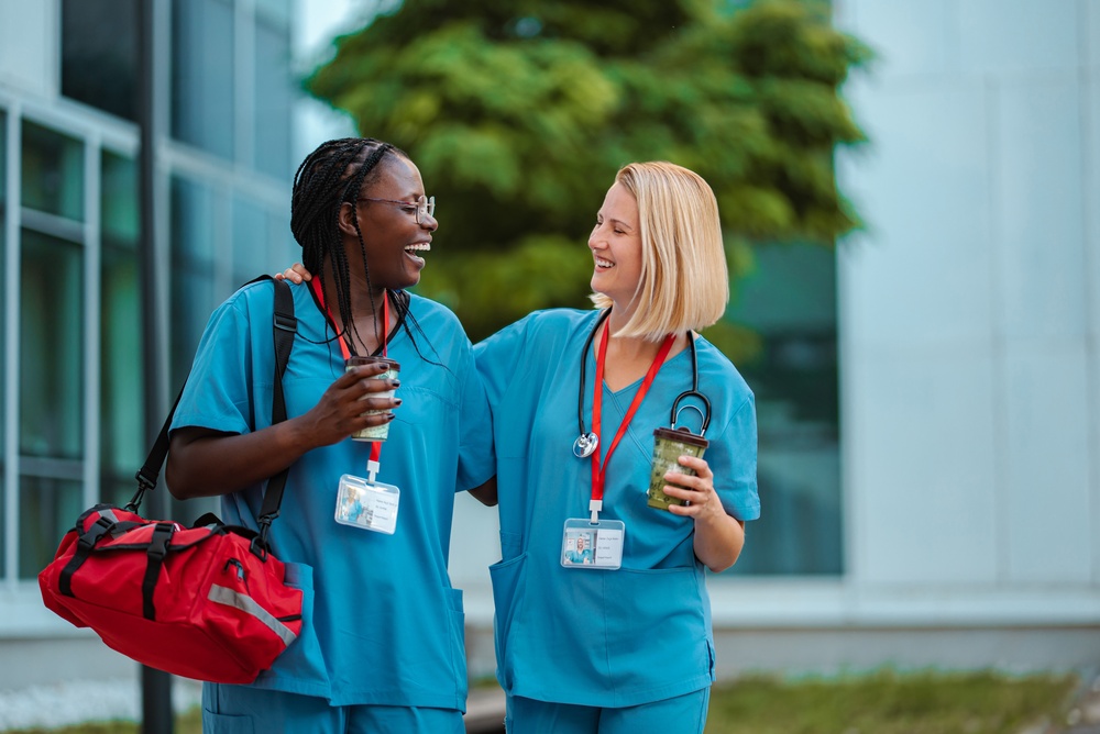 Healthcare workers sharing a candid moment outside a hospital, illustrating how a corporate storytelling video can capture the people, culture, and human relationships behind an organization.