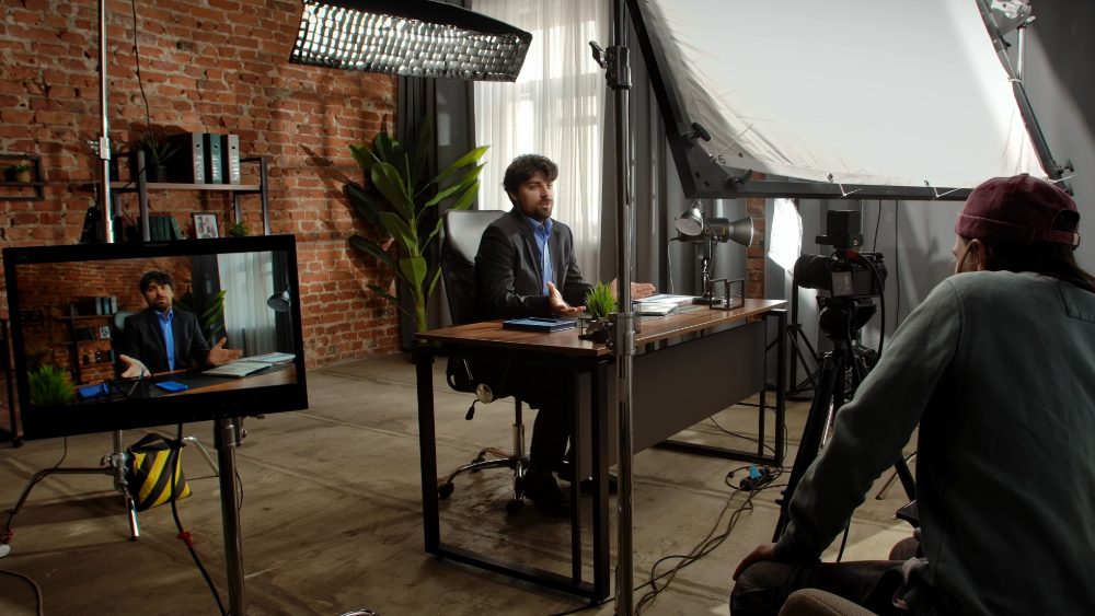Film crew recording a seated interview in an office studio, the master story at the heart of a video content strategy.