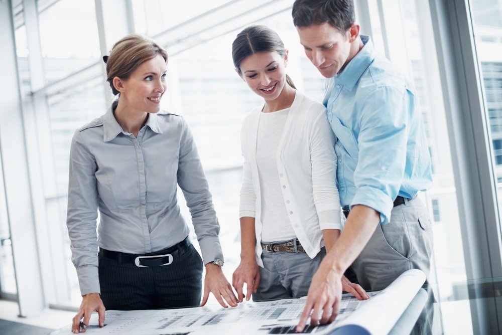 Architect and couple reviewing a blueprint and budget documents, illustrating home improvement marketing for homeowners