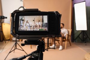 Film crew recording an interview with two people in a studio, the kind of shoot behind many video marketing examples.