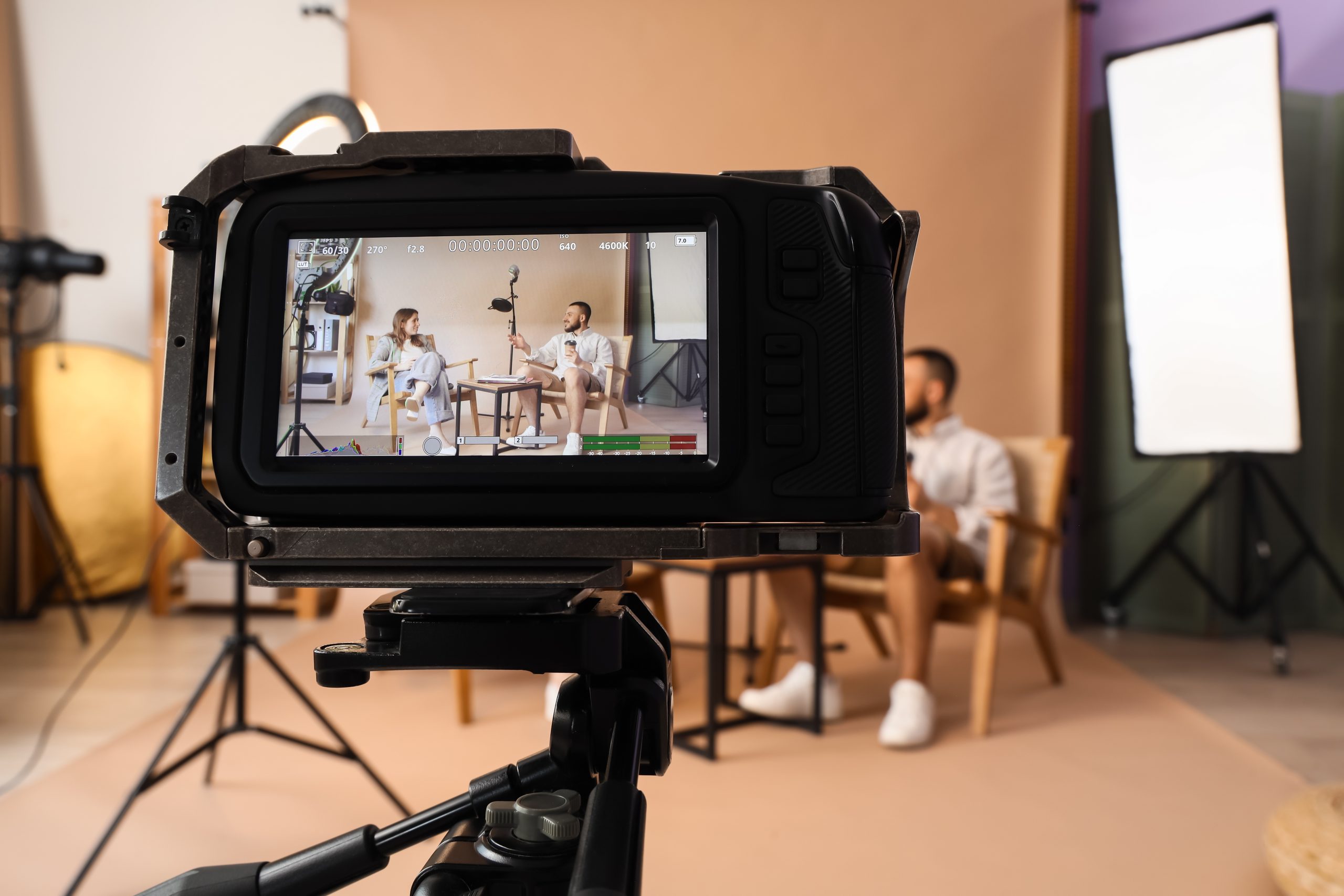 Film crew recording an interview with two people in a studio, the kind of shoot behind many video marketing examples.