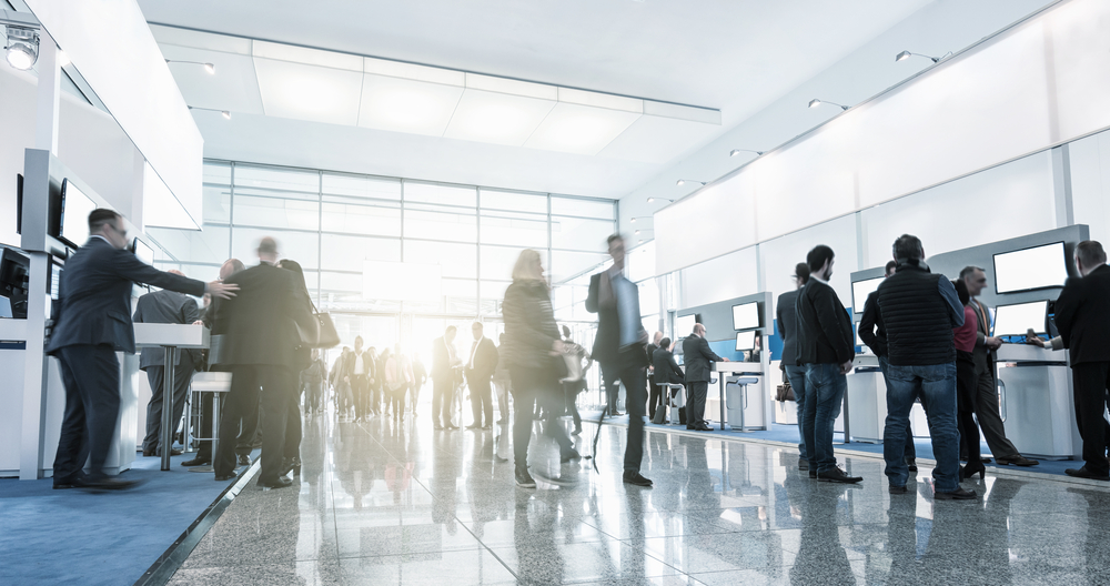 Visitors walking between trade fair stands, a demand generation strategy example